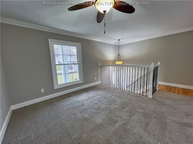 empty room featuring dark carpet, ornamental molding, and ceiling fan