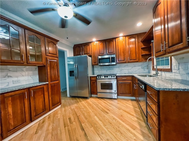 kitchen with backsplash, light hardwood / wood-style floors, stainless steel appliances, and ceiling fan