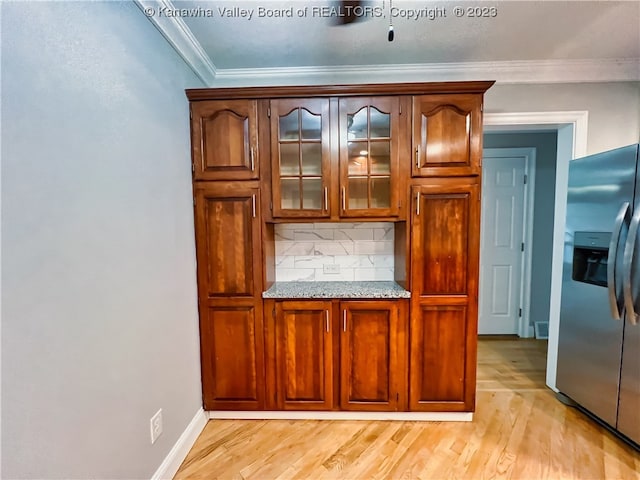 kitchen with backsplash, stainless steel fridge with ice dispenser, light hardwood / wood-style floors, light stone counters, and ornamental molding