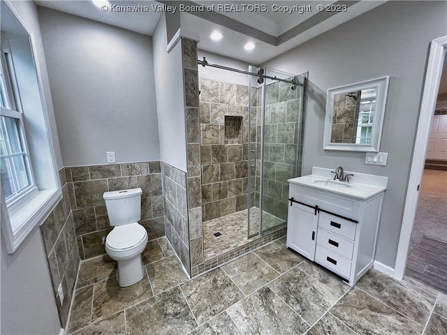 bathroom with toilet, tile flooring, walk in shower, and vanity with extensive cabinet space