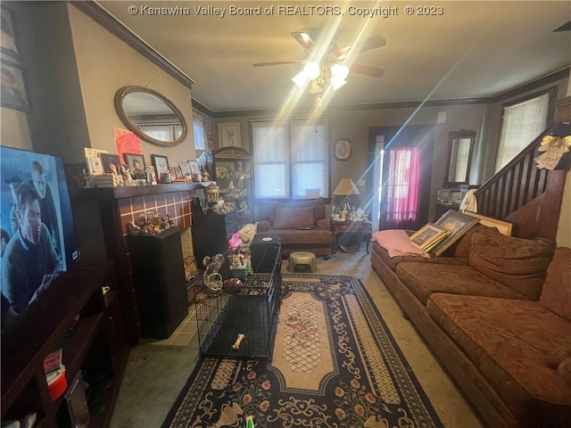 carpeted living room featuring ceiling fan, a tile fireplace, and ornamental molding