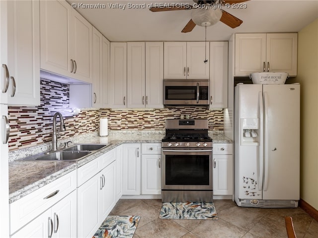 kitchen featuring stainless steel appliances, sink, white cabinetry, and backsplash