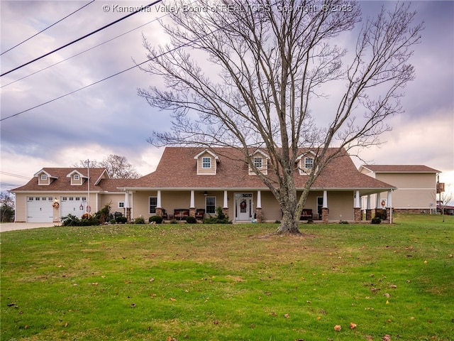 cape cod-style house with covered porch, a garage, and a front yard