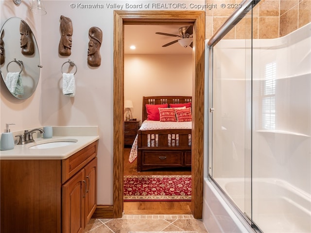 bathroom featuring ceiling fan, combined bath / shower with glass door, oversized vanity, and hardwood / wood-style flooring