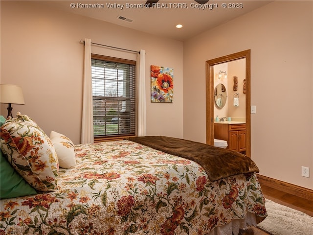 bedroom with sink, hardwood / wood-style flooring, and ensuite bathroom