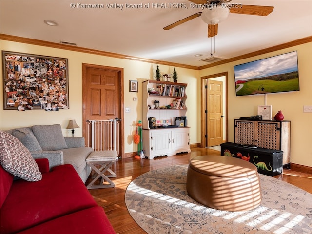 living room with dark hardwood / wood-style flooring, ornamental molding, and ceiling fan