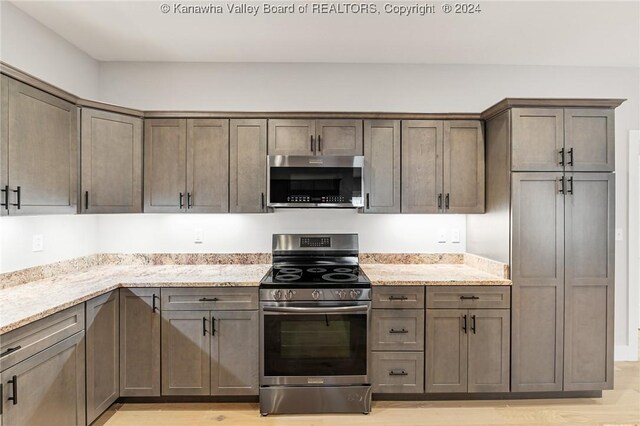 227 Woodland Dr, Milton, WV 25541 - kitchen with appliances with stainless steel finishes, light stone counters, and light wood-style floors