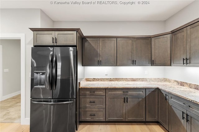 227 Woodland Dr, Milton, WV 25541 - kitchen with stainless steel fridge, light stone counters, dark brown cabinets, and light wood finished floors