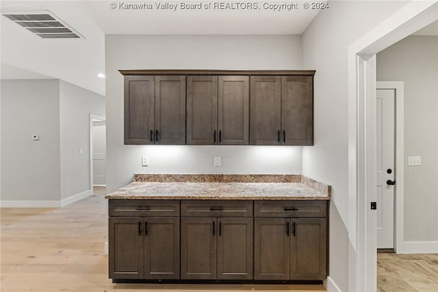 227 Woodland Dr, Milton, WV 25541 - kitchen with baseboards, dark brown cabinets, light stone countertops, and light wood-type flooring