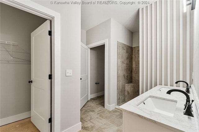 227 Woodland Dr, Milton, WV 25541 - bathroom featuring baseboards, tiled shower, and double vanity