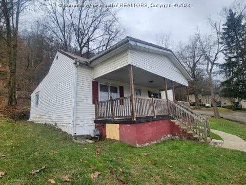 view of property exterior featuring a lawn and covered porch