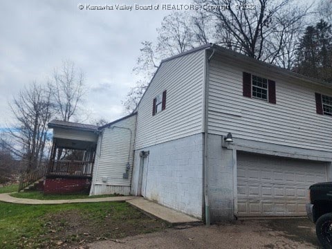 view of side of home with a porch and a garage