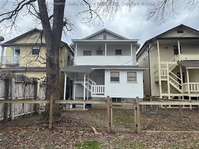 back of property with a balcony and covered porch