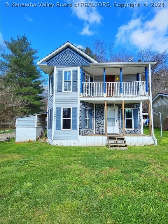 back of property featuring a balcony, an outdoor structure, and a lawn