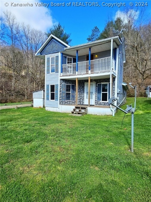 back of house featuring a balcony and a yard