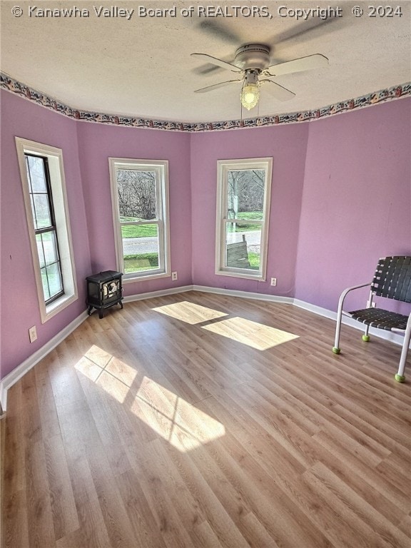 interior space featuring light hardwood / wood-style flooring, ceiling fan, and a textured ceiling