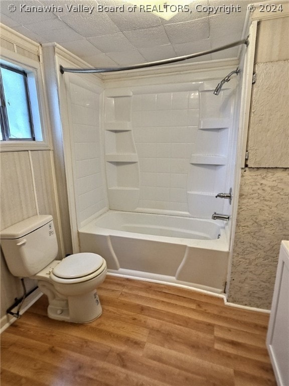 full bathroom with shower / washtub combination, toilet, and hardwood / wood-style floors