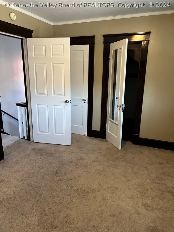 unfurnished bedroom with ornamental molding and light colored carpet