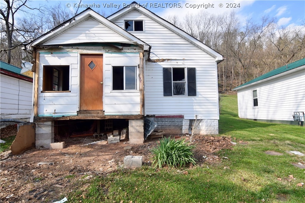 rear view of property featuring a lawn