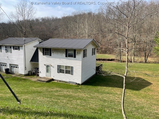 rear view of property with a lawn and a garage