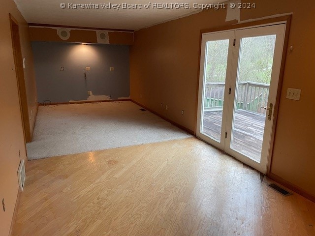 empty room with light hardwood / wood-style floors and plenty of natural light