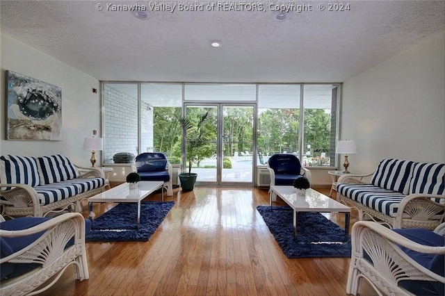 living room with a textured ceiling and light wood-type flooring