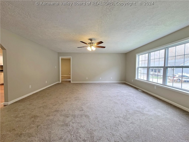 unfurnished room featuring carpet flooring, a textured ceiling, and ceiling fan