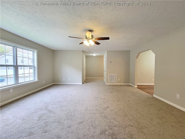 spare room with carpet, a textured ceiling, and ceiling fan