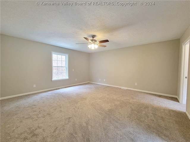 carpeted empty room featuring ceiling fan and a textured ceiling