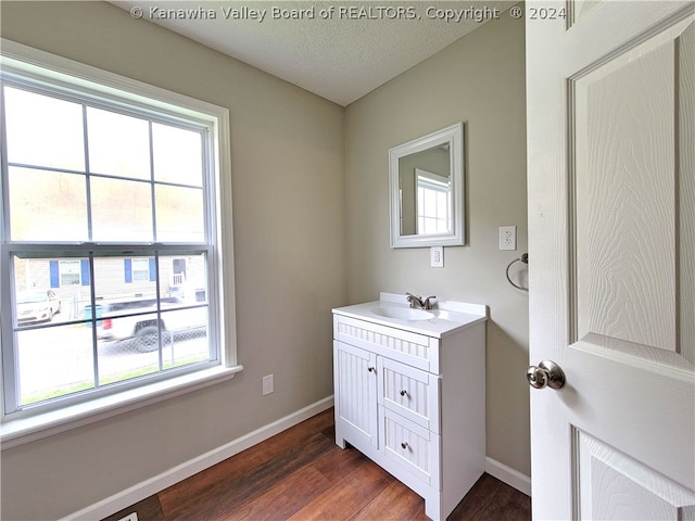 bathroom featuring hardwood / wood-style flooring, vanity, and a textured ceiling