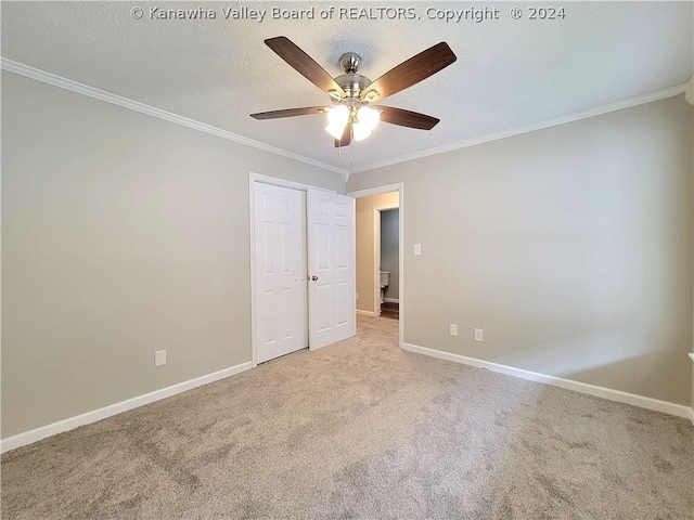 unfurnished room with ceiling fan, ornamental molding, light carpet, and a textured ceiling