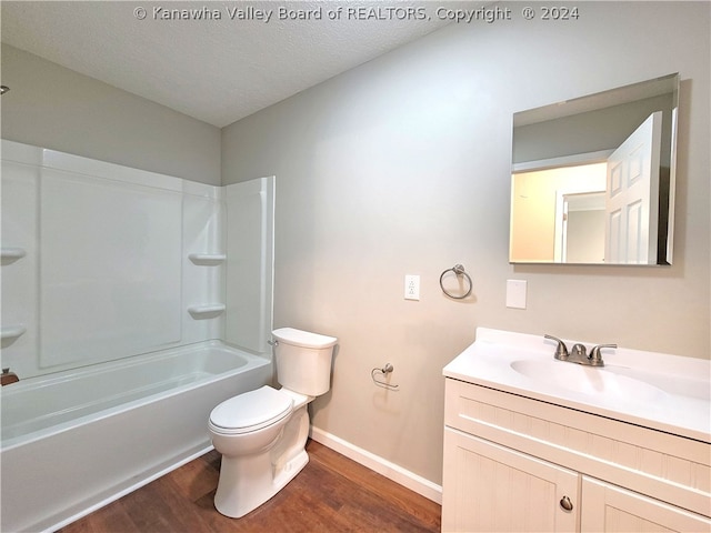 full bathroom featuring shower / tub combination, hardwood / wood-style flooring, vanity, toilet, and a textured ceiling