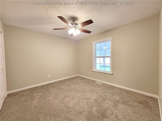 unfurnished room with ceiling fan, carpet floors, and a textured ceiling