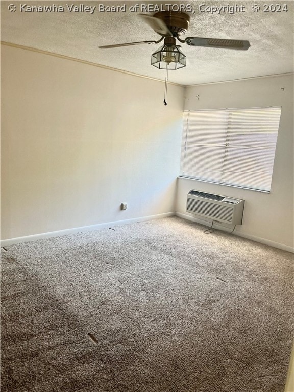 carpeted spare room featuring a textured ceiling, ceiling fan, and a wall mounted air conditioner