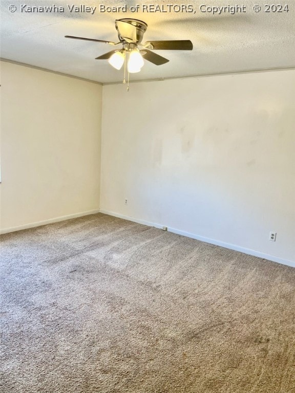 empty room featuring ceiling fan, carpet, and a textured ceiling