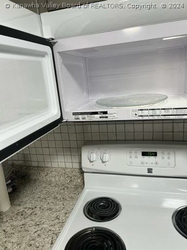 interior space with light stone counters, white appliances, and tasteful backsplash