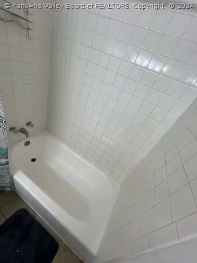 bathroom featuring tile flooring and tiled shower / bath