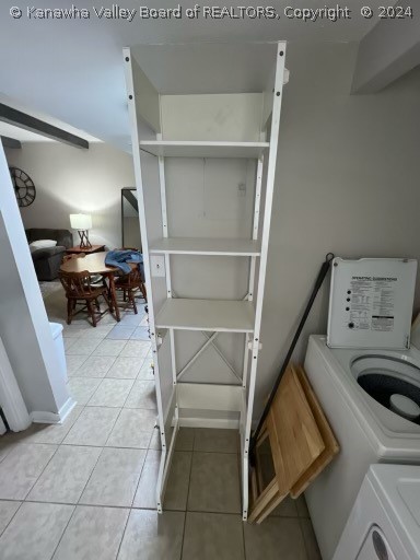 washroom with light tile flooring and washer and clothes dryer