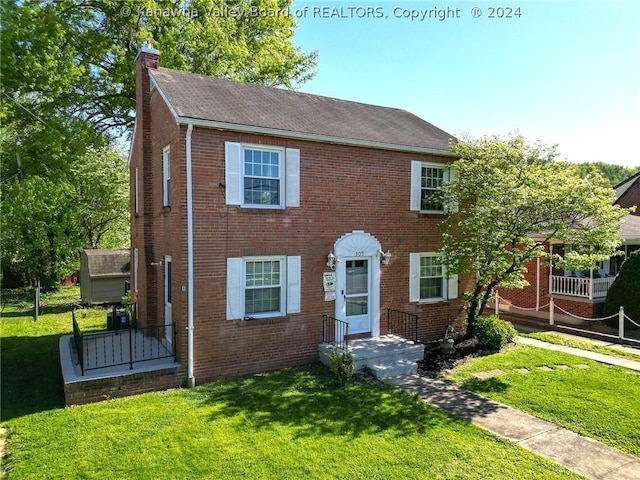 colonial inspired home featuring a front lawn