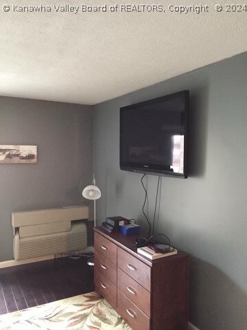 bedroom with hardwood / wood-style floors and a textured ceiling