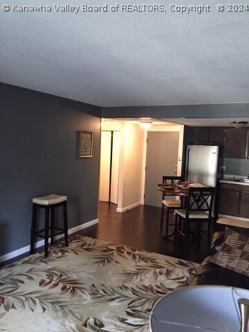 living room featuring a textured ceiling and dark hardwood / wood-style flooring