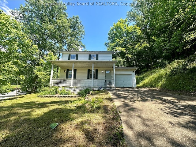 view of front of home with a front lawn, a garage, and a porch