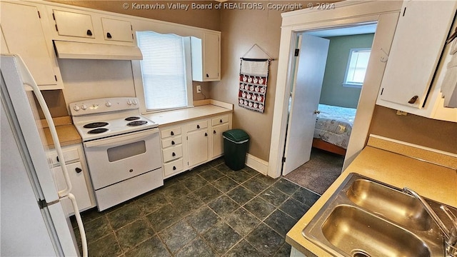 kitchen featuring white appliances, white cabinetry, and sink