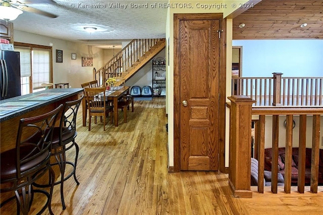 interior space with ceiling fan, a textured ceiling, and light wood-type flooring