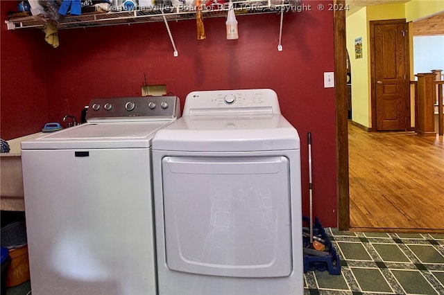 washroom featuring hardwood / wood-style floors and washer and clothes dryer