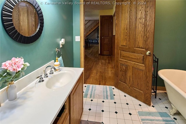 bathroom featuring a tub to relax in, tile patterned flooring, and vanity