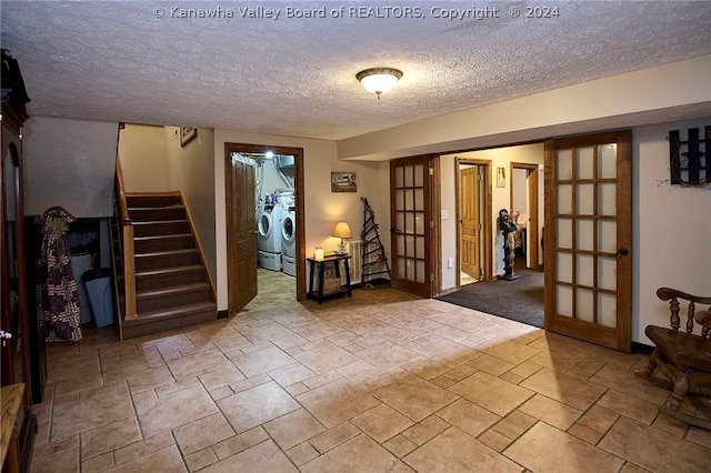 interior space featuring washing machine and dryer, french doors, and a textured ceiling