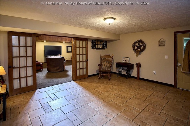 sitting room with a textured ceiling and french doors