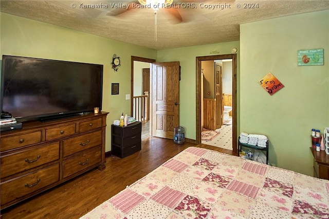 bedroom with ceiling fan, dark hardwood / wood-style flooring, ensuite bath, and a textured ceiling