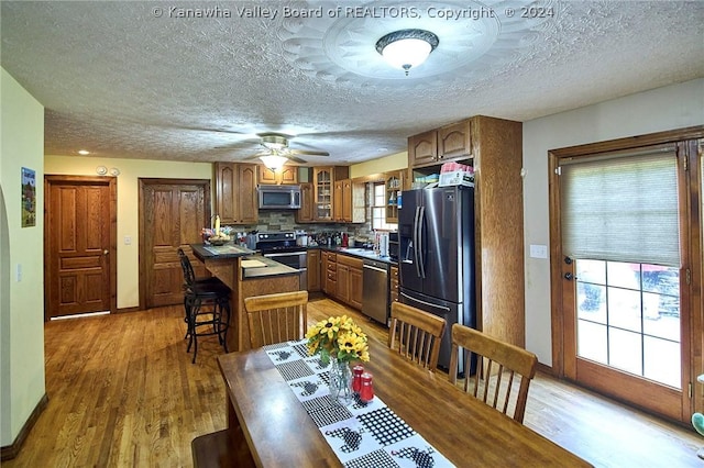 kitchen with hardwood / wood-style floors, backsplash, a breakfast bar area, and stainless steel appliances